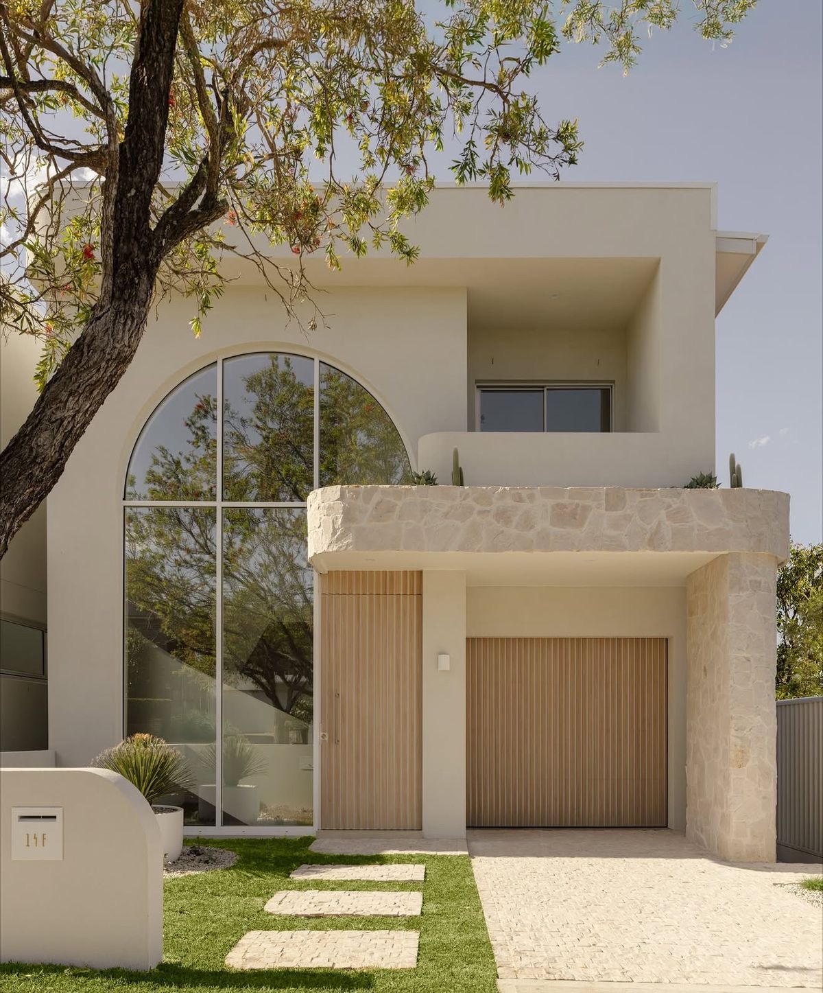 Completed new construction modern home with arched window and stone facade in Los Angeles